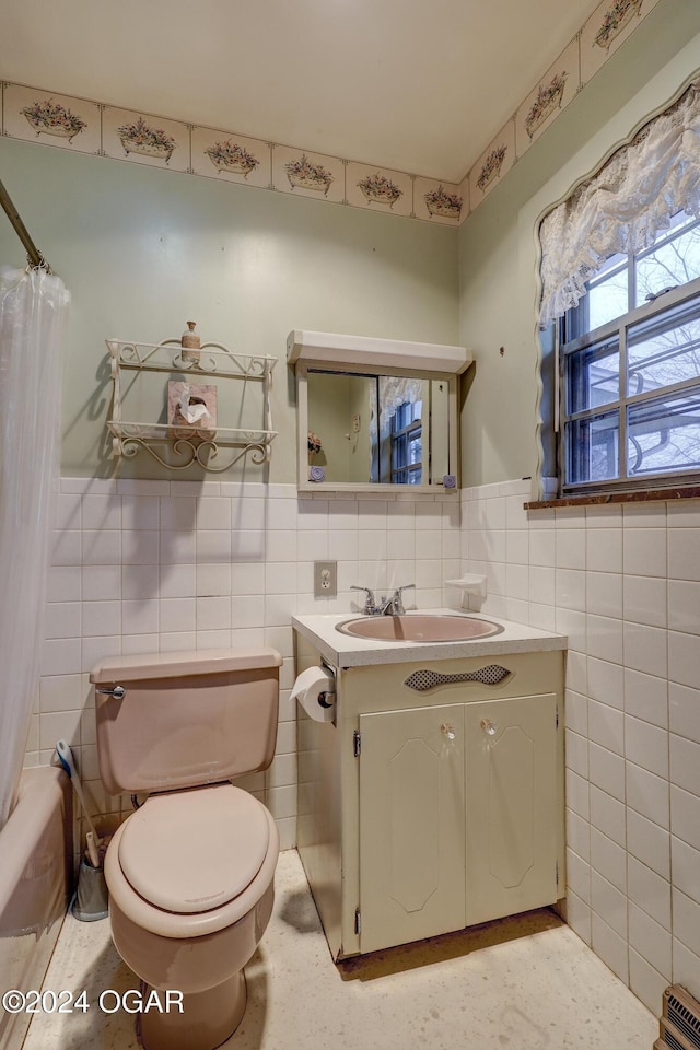 bathroom featuring vanity, tile walls, and toilet