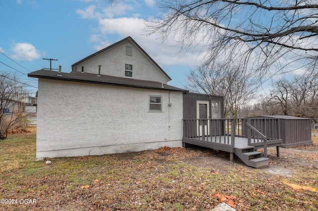 back of property with a wooden deck and a yard