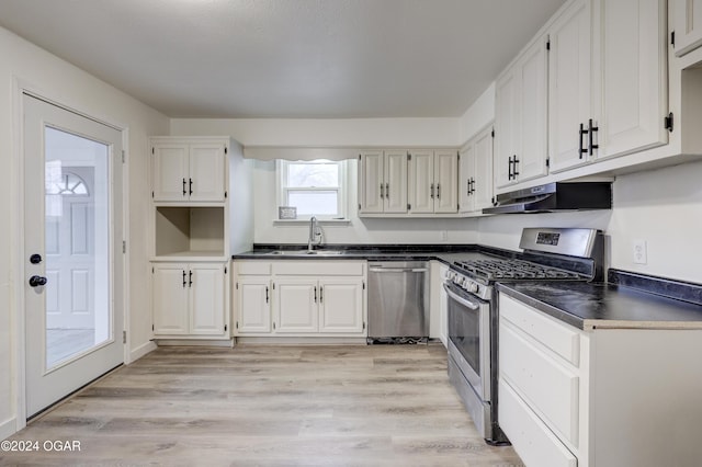 kitchen with sink, white cabinets, light wood-type flooring, and appliances with stainless steel finishes