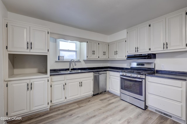 kitchen with appliances with stainless steel finishes, light hardwood / wood-style flooring, white cabinetry, and sink