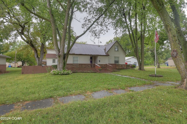 view of front of property featuring a front yard and a deck