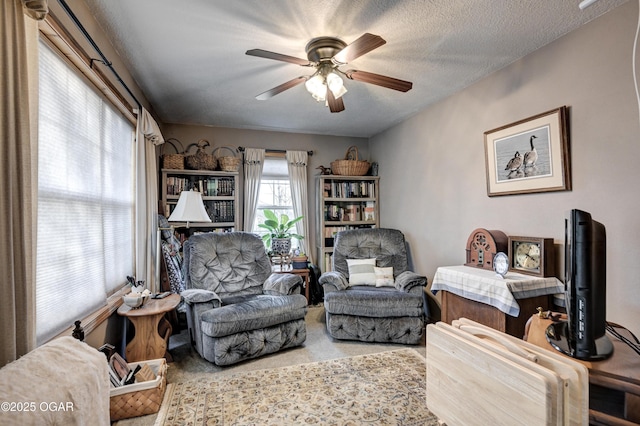 sitting room featuring carpet flooring, a textured ceiling, and ceiling fan