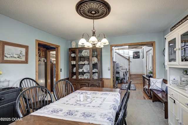 dining space featuring a textured ceiling and a notable chandelier