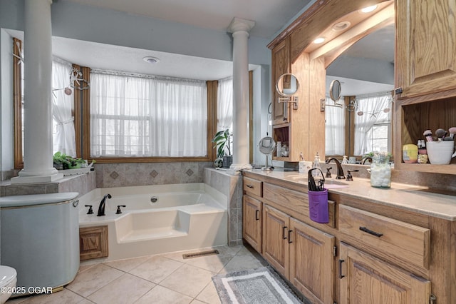 bathroom featuring a tub to relax in, tile patterned flooring, decorative columns, and toilet