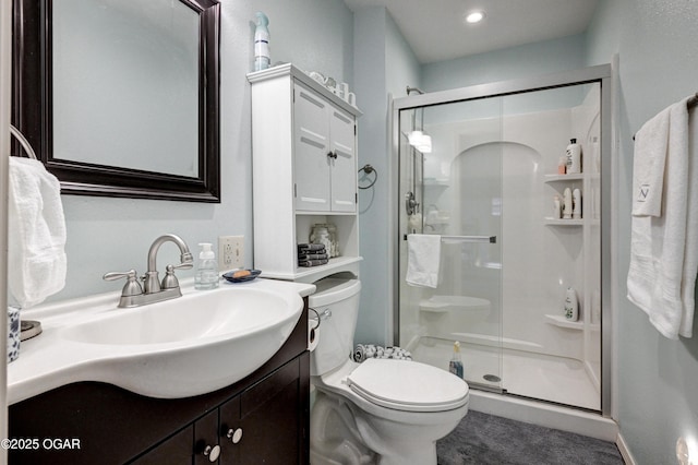 bathroom featuring vanity, toilet, and a shower with shower door