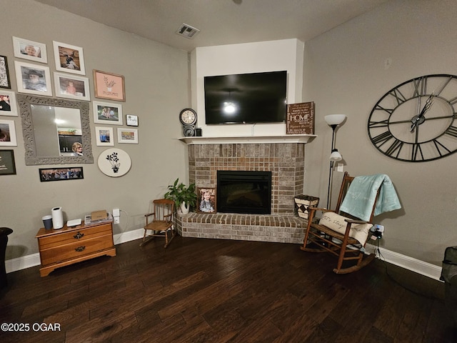 sitting room with wood-type flooring and a brick fireplace