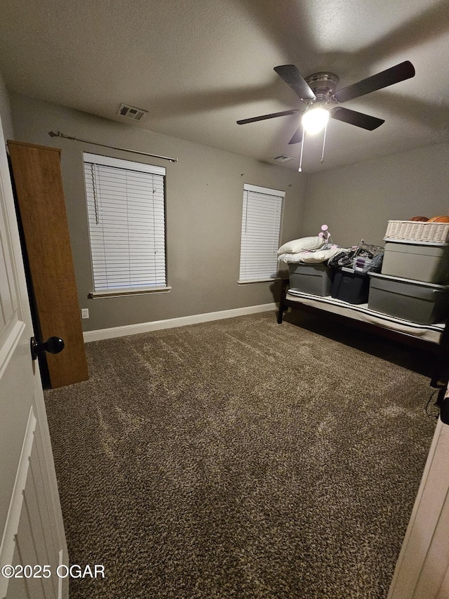 bedroom featuring ceiling fan, carpet floors, and a textured ceiling