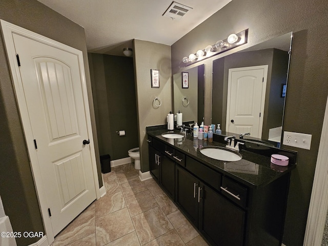 bathroom with tile patterned flooring, vanity, and toilet