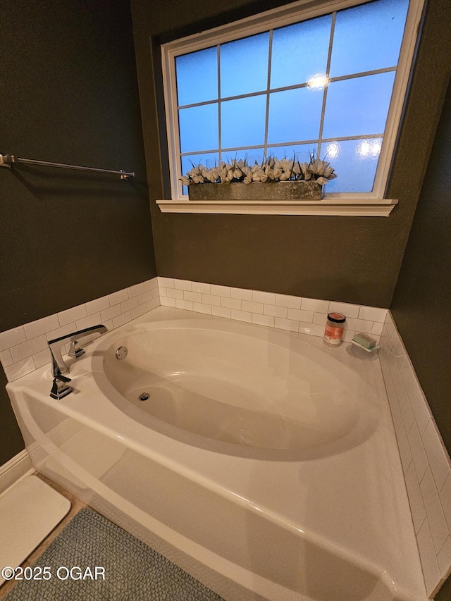 bathroom featuring a tub to relax in, tile patterned floors, and a healthy amount of sunlight