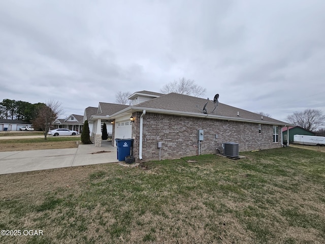 view of side of property with central AC unit, a garage, and a yard