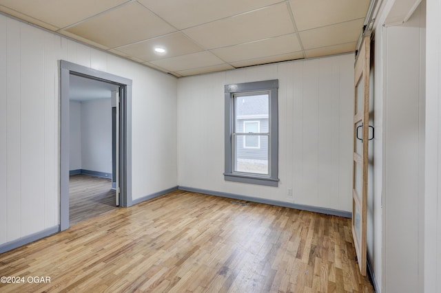 unfurnished room featuring a paneled ceiling and light hardwood / wood-style flooring