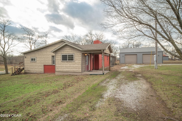 view of front of property featuring a front lawn, an outdoor structure, and a garage