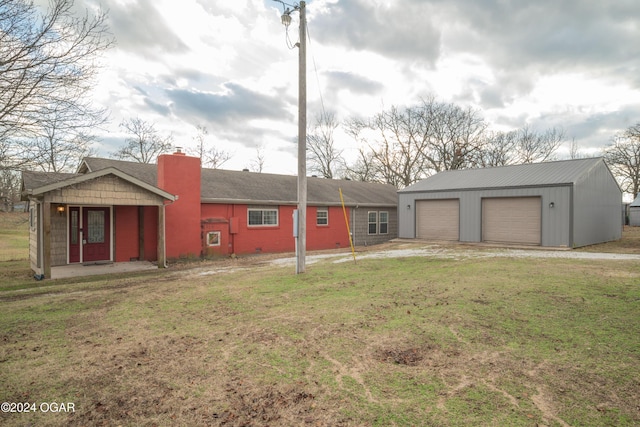 view of front of home with a front lawn, an outdoor structure, and a garage