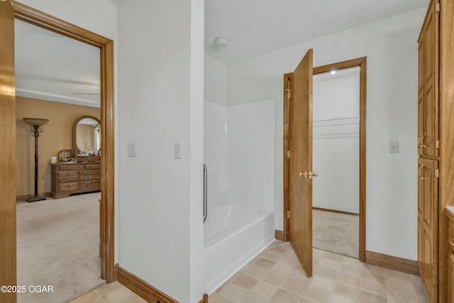 bathroom with a textured ceiling and a bathtub