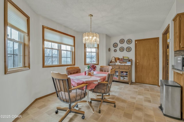 dining room with a chandelier, a textured ceiling, and plenty of natural light