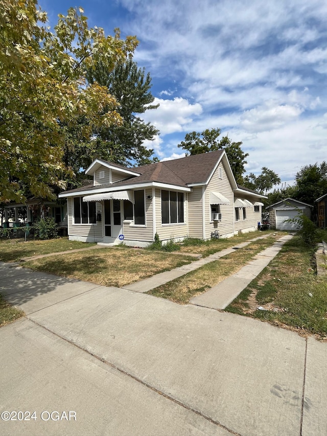 view of front of house featuring an outbuilding, a garage, and a front yard