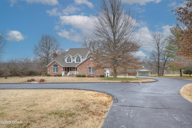 view of front of house featuring a front yard, an outdoor structure, and a garage