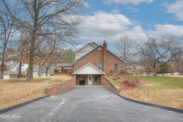 view of side of home featuring a lawn and covered porch