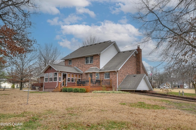 back of house featuring a yard, a deck, and a sunroom