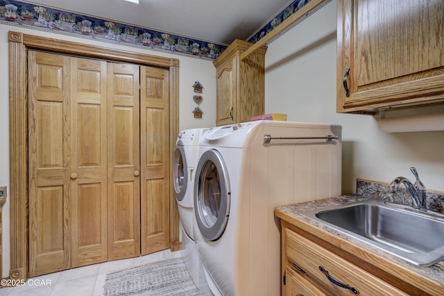 washroom with cabinets, light tile patterned floors, separate washer and dryer, and sink