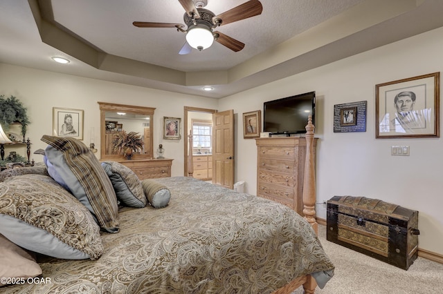 bedroom featuring ceiling fan, a raised ceiling, and light carpet