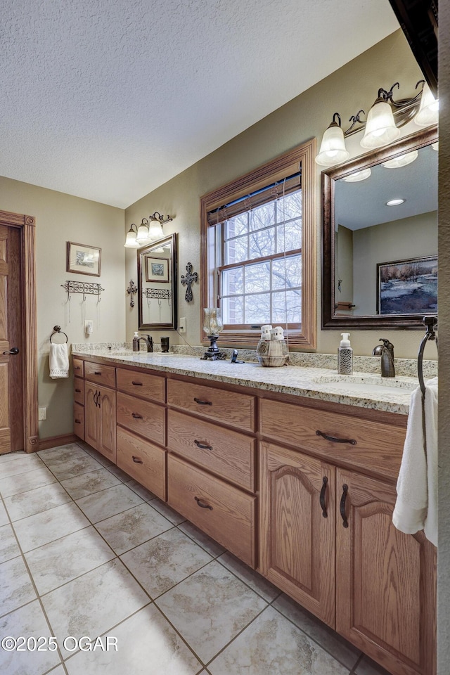 bathroom featuring tile patterned flooring, vanity, and a textured ceiling