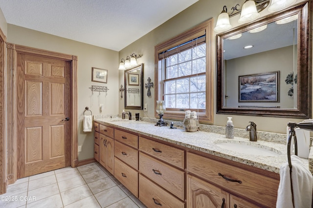 bathroom featuring tile patterned flooring, vanity, and a textured ceiling