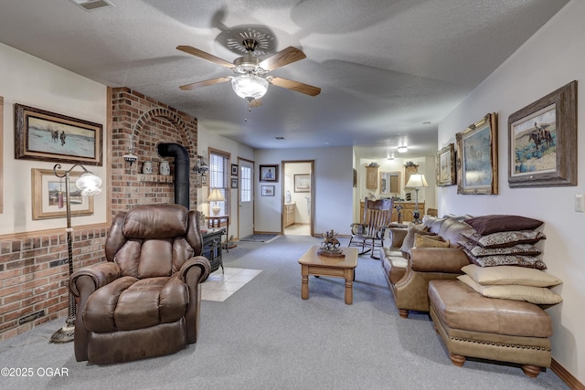 carpeted living room with ceiling fan, a wood stove, and a textured ceiling