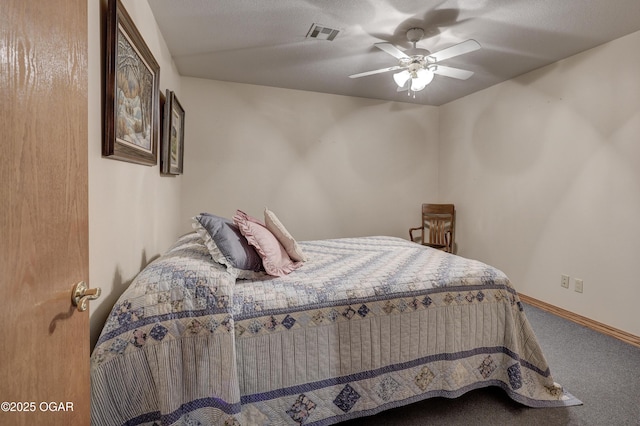 carpeted bedroom featuring ceiling fan and a textured ceiling