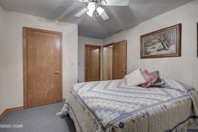 bedroom with ceiling fan, carpet floors, and a textured ceiling