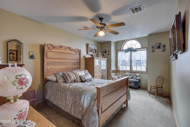 carpeted bedroom featuring a textured ceiling and ceiling fan