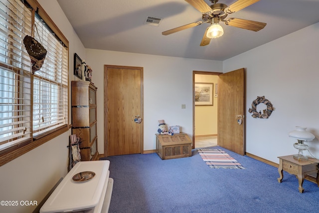 interior space with dark carpet and ceiling fan