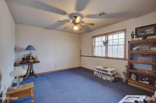 misc room featuring ceiling fan, carpet floors, and a textured ceiling