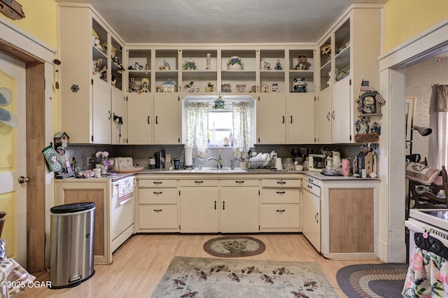 kitchen with decorative backsplash, cream cabinets, light hardwood / wood-style floors, and sink