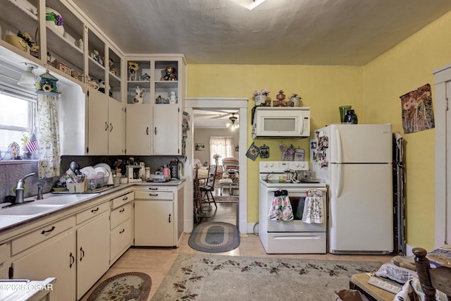 kitchen featuring ceiling fan, sink, and white appliances