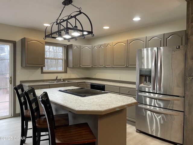 kitchen featuring stainless steel refrigerator with ice dispenser, a kitchen island, gray cabinetry, and sink