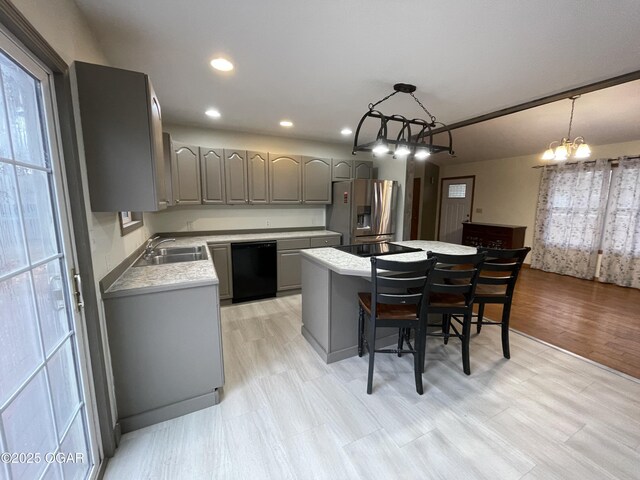 kitchen with a center island, a notable chandelier, decorative light fixtures, gray cabinets, and black appliances