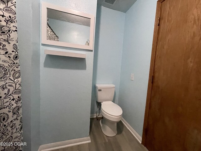 bathroom with hardwood / wood-style floors and toilet