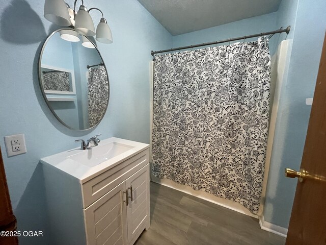 bathroom featuring a chandelier, wood-type flooring, vanity, and a textured ceiling