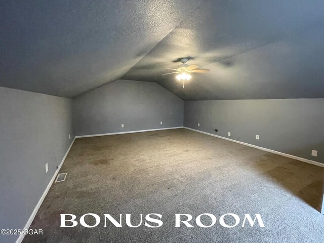 bonus room featuring carpet flooring, ceiling fan, lofted ceiling, and a textured ceiling