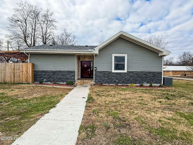 view of front of home with a front yard and central AC