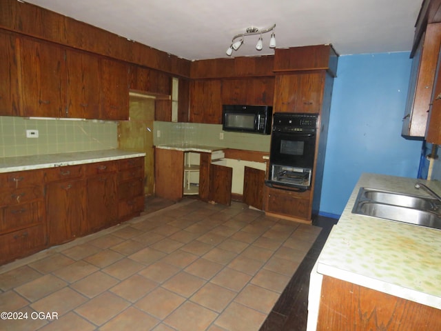 kitchen with decorative backsplash, sink, tile patterned flooring, and black appliances