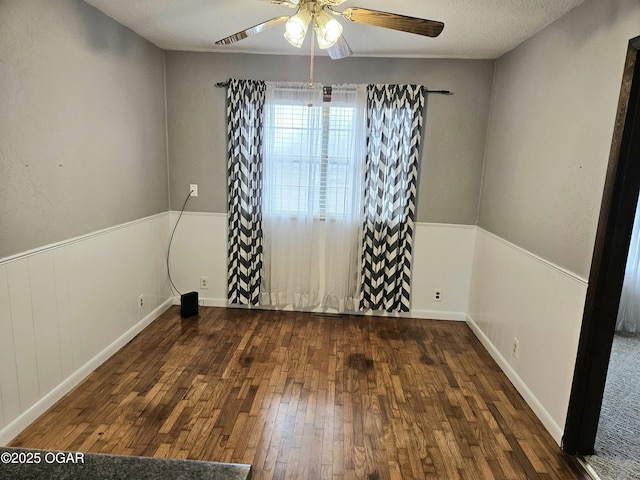 spare room with ceiling fan, dark hardwood / wood-style flooring, and a textured ceiling