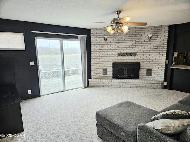 living room featuring carpet, ceiling fan, and a textured ceiling