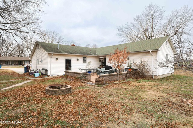 202 Arbor Dr, Lamar, MO 64759 - back of house with a lawn, an outdoor fire pit, and a patio