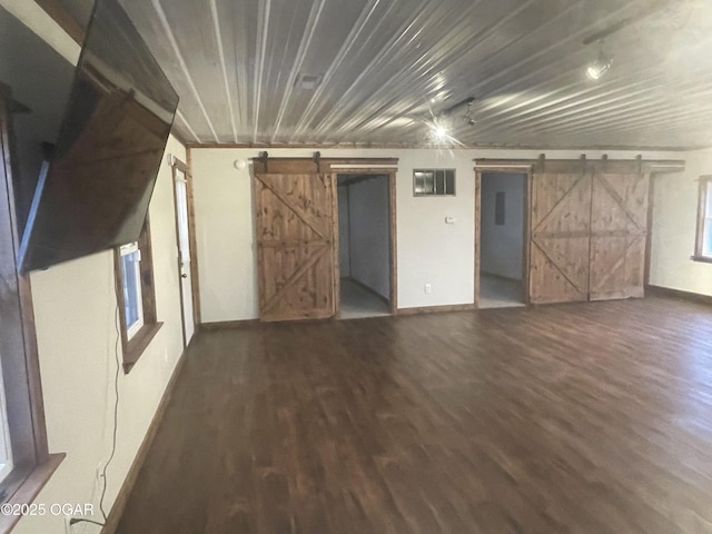 interior space with dark hardwood / wood-style flooring and a barn door