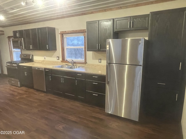 kitchen with appliances with stainless steel finishes, dark wood-type flooring, and sink