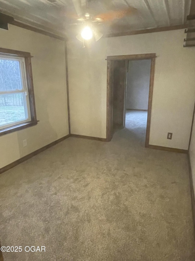 carpeted spare room featuring ceiling fan