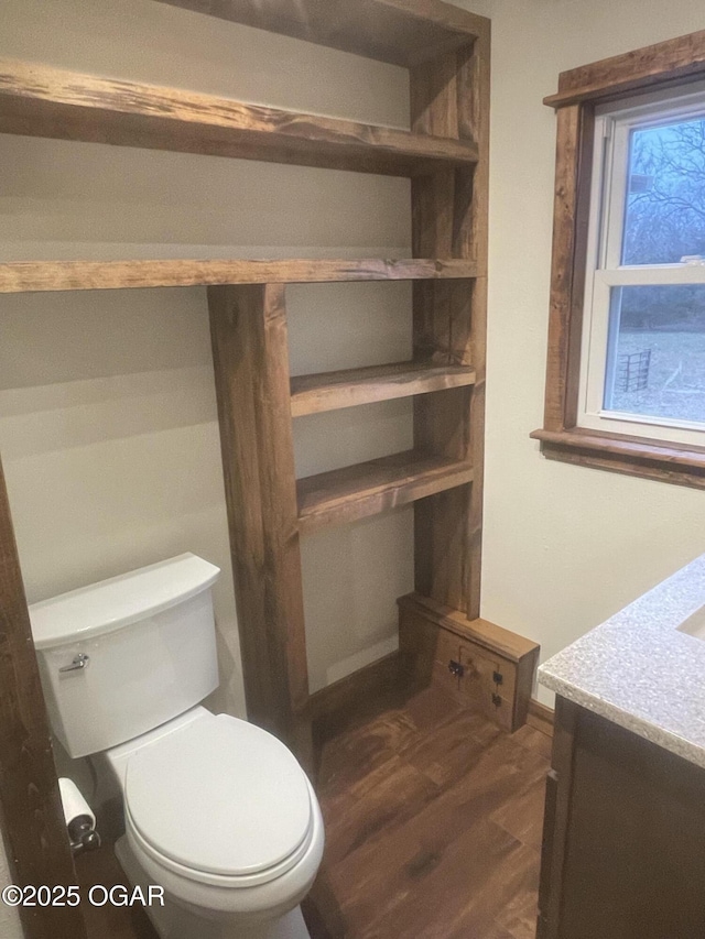 bathroom with toilet, wood-type flooring, and vanity