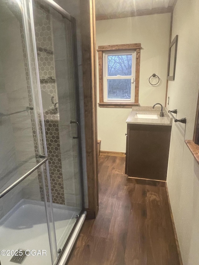 bathroom with hardwood / wood-style floors, an enclosed shower, and vanity